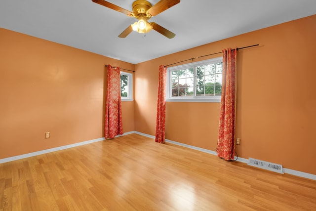 empty room with ceiling fan and light hardwood / wood-style flooring