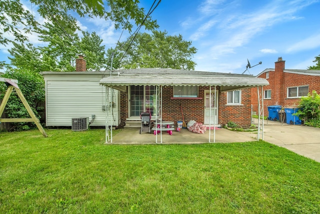 back of house with a lawn, central air condition unit, and a patio