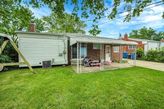 rear view of house featuring a lawn, a patio area, and central AC unit