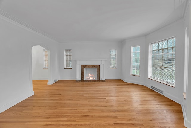 unfurnished living room featuring a fireplace, crown molding, and light hardwood / wood-style flooring