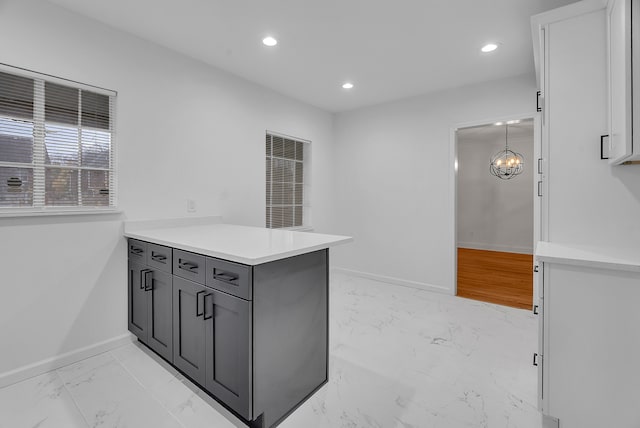 kitchen featuring kitchen peninsula, gray cabinets, and hanging light fixtures