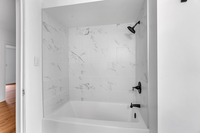 bathroom with wood-type flooring and tiled shower / bath