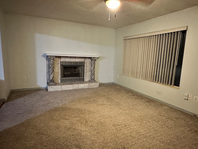 unfurnished living room featuring ceiling fan, a fireplace, and carpet floors