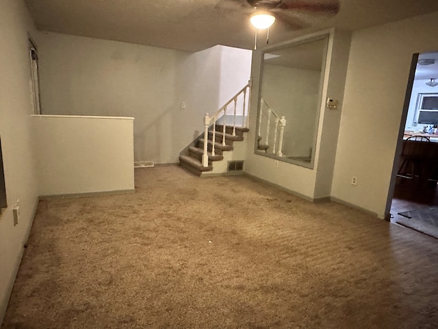 basement featuring ceiling fan and carpet floors