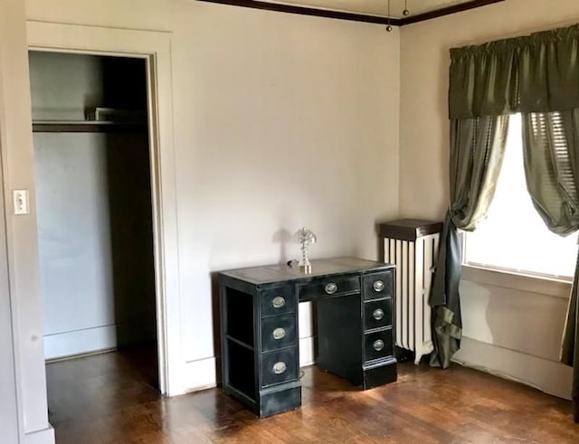 home office with radiator heating unit, dark hardwood / wood-style floors, and ornamental molding