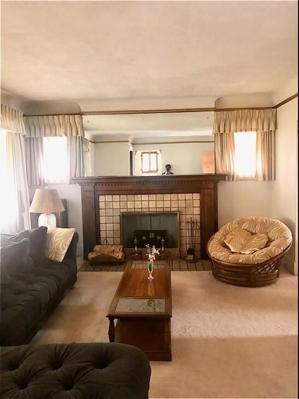 living room with a tile fireplace and carpet