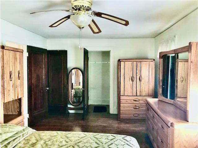 unfurnished bedroom featuring ceiling fan and dark wood-type flooring