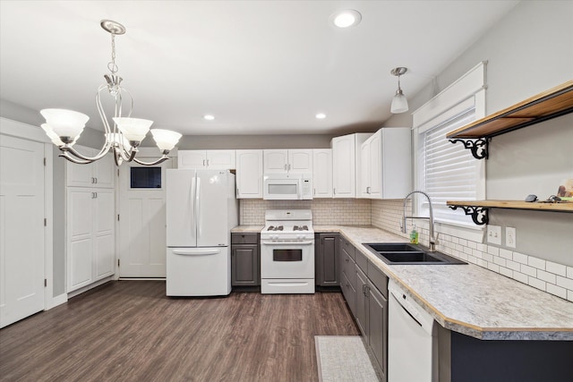 kitchen featuring sink, white cabinets, decorative light fixtures, and white appliances