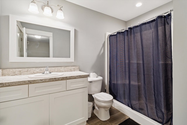 bathroom with curtained shower, toilet, vanity, and hardwood / wood-style flooring