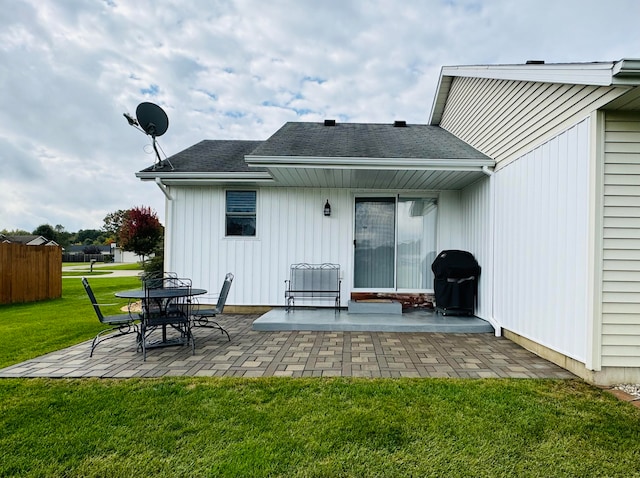 back of property with a yard and a patio