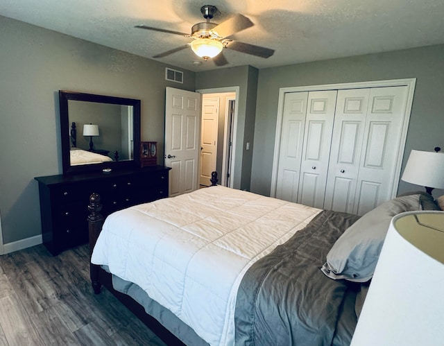 bedroom featuring a textured ceiling, ceiling fan, dark wood-type flooring, and a closet