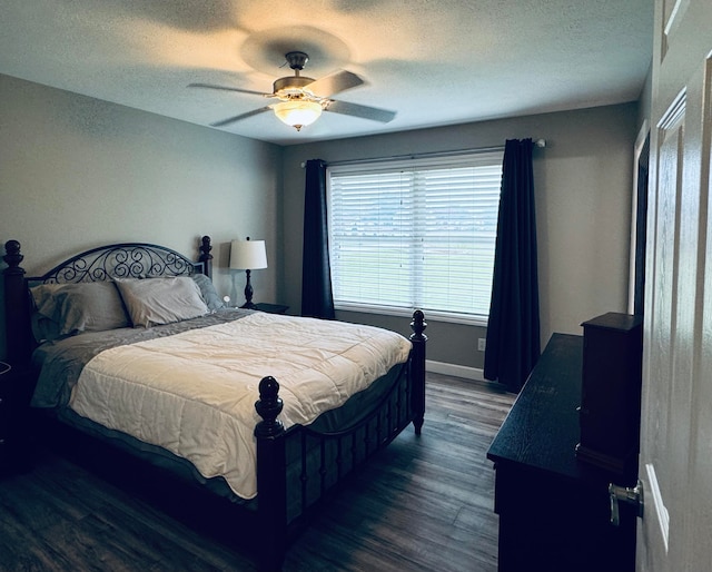 bedroom featuring ceiling fan, dark wood-type flooring, and a textured ceiling