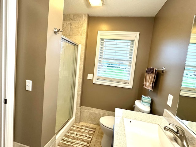 bathroom featuring tile patterned floors, vanity, toilet, and walk in shower