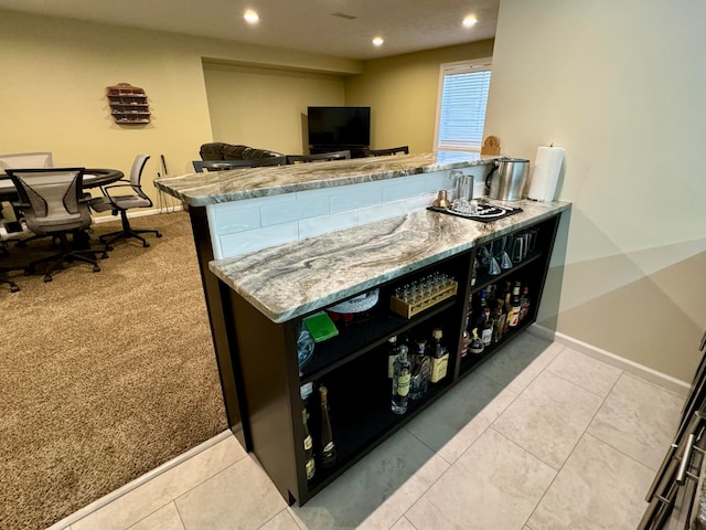 bar with light stone countertops and light colored carpet