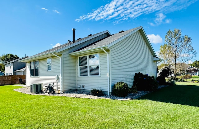 back of property featuring a lawn and central air condition unit