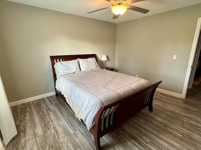 bedroom featuring ceiling fan, wood-type flooring, and a textured ceiling