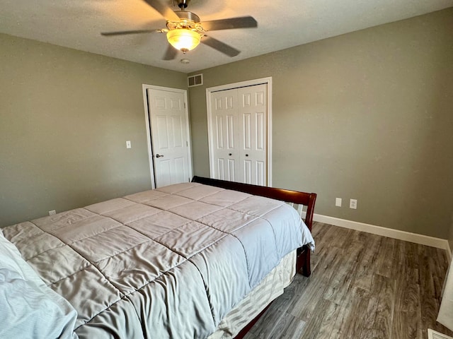 bedroom with a textured ceiling, hardwood / wood-style flooring, a closet, and ceiling fan