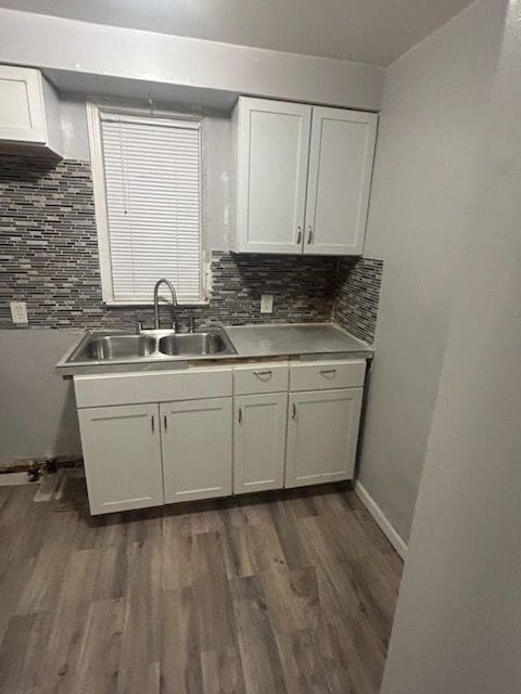 kitchen with decorative backsplash, sink, white cabinets, and dark wood-type flooring