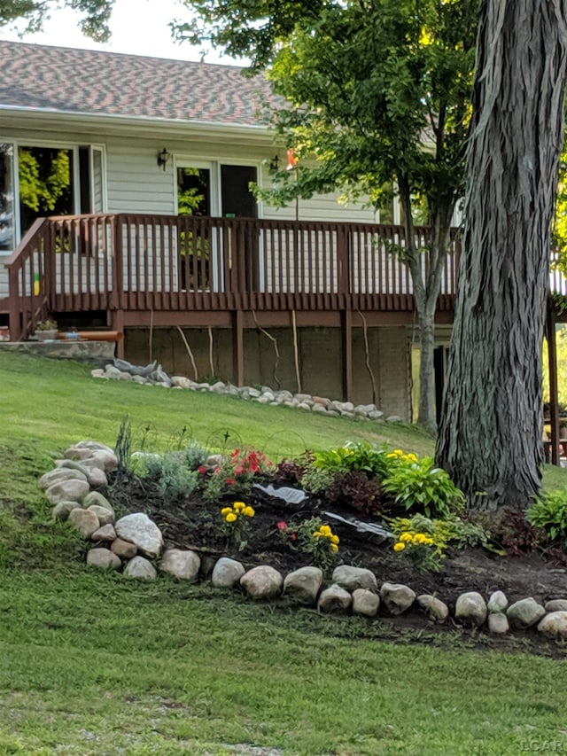 rear view of house with a deck and a yard