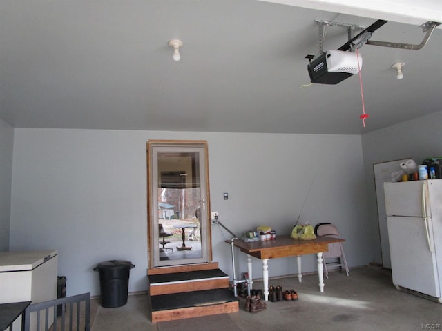 garage featuring white refrigerator and a garage door opener