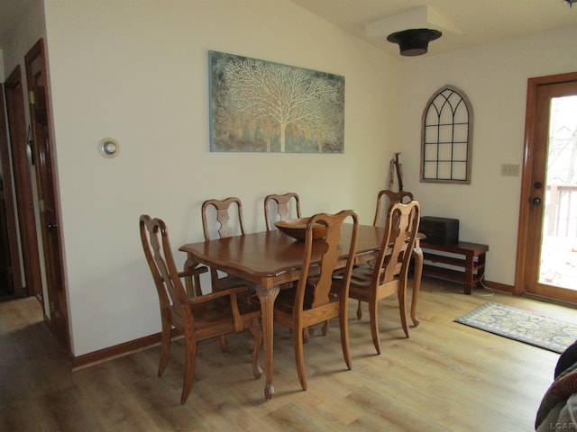 dining area featuring plenty of natural light, light hardwood / wood-style floors, and vaulted ceiling