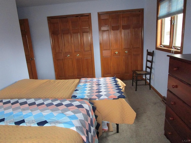 carpeted bedroom featuring two closets