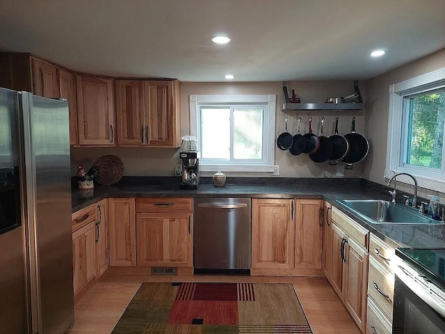 kitchen featuring sink, light wood-type flooring, and appliances with stainless steel finishes