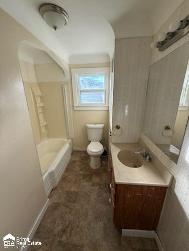 full bathroom with vanity, toilet, tile walls, and bathtub / shower combination