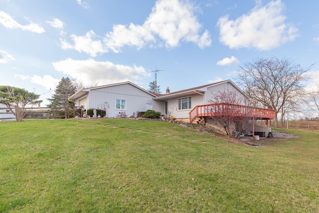 back of property featuring a deck and a yard