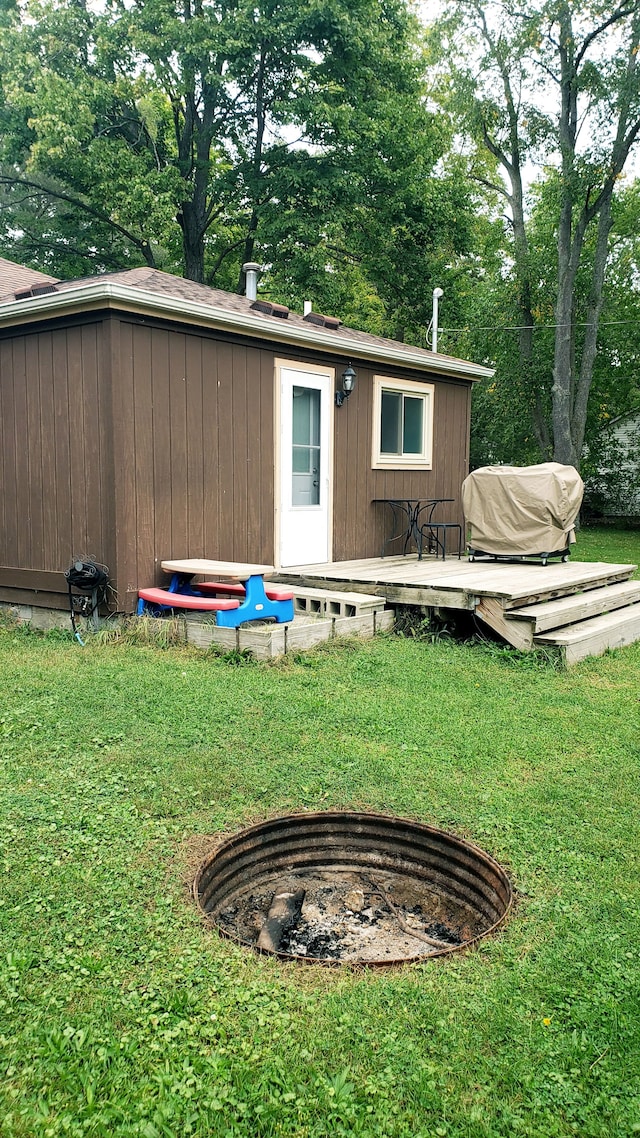 rear view of property featuring a lawn and a wooden deck