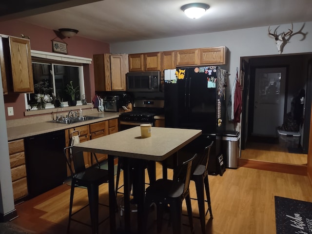 kitchen with sink, black appliances, and light wood-type flooring