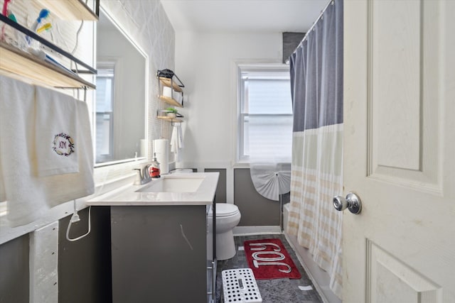 bathroom featuring plenty of natural light, toilet, and vanity