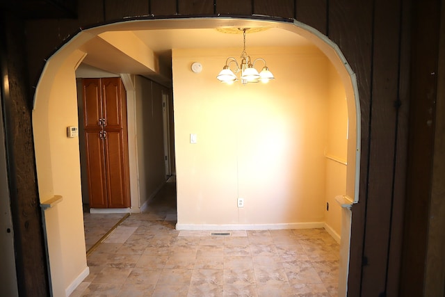 unfurnished dining area featuring a chandelier