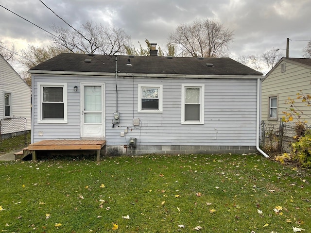 back of house featuring a wooden deck and a lawn