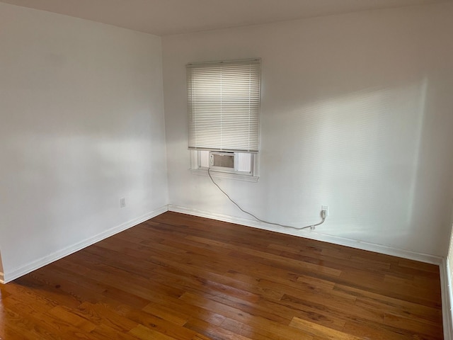 spare room with cooling unit and hardwood / wood-style flooring