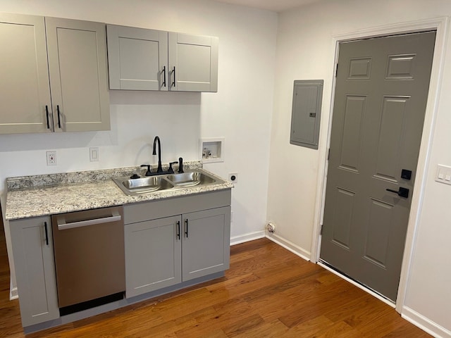 kitchen featuring sink, stainless steel dishwasher, electric panel, gray cabinets, and hardwood / wood-style flooring