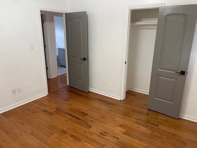 unfurnished bedroom featuring wood-type flooring and a closet