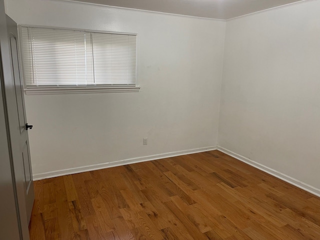 spare room featuring wood-type flooring and ornamental molding