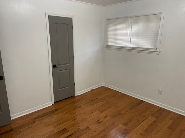 unfurnished room with crown molding and hardwood / wood-style flooring