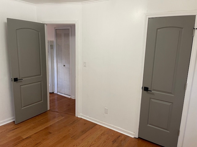 empty room featuring hardwood / wood-style flooring and crown molding