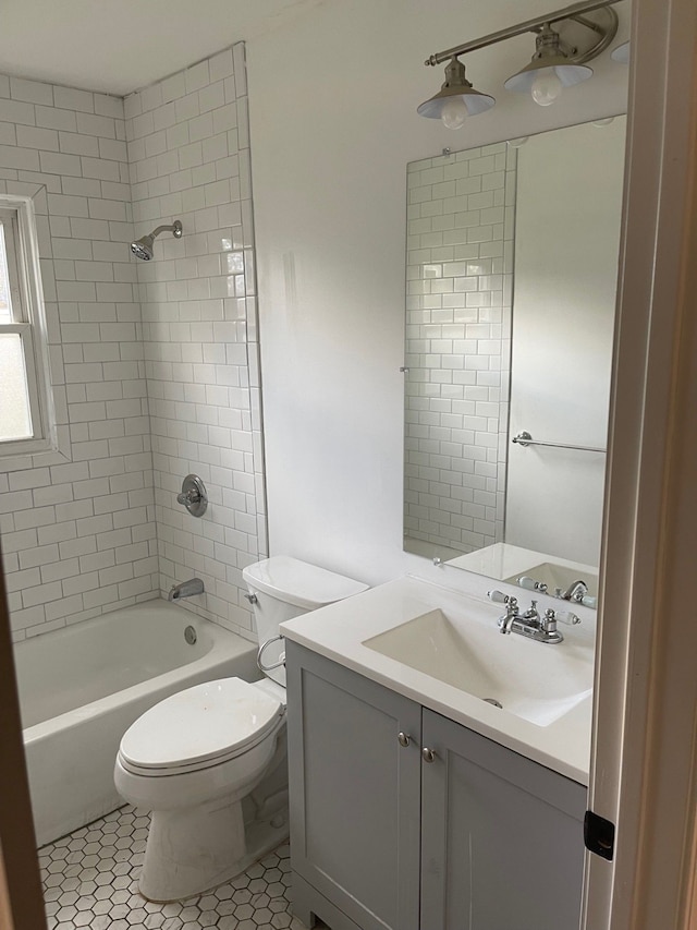 full bathroom with tile patterned flooring, vanity, toilet, and tiled shower / bath