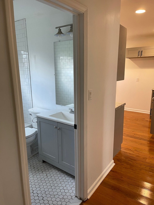 bathroom with vanity, toilet, and wood-type flooring