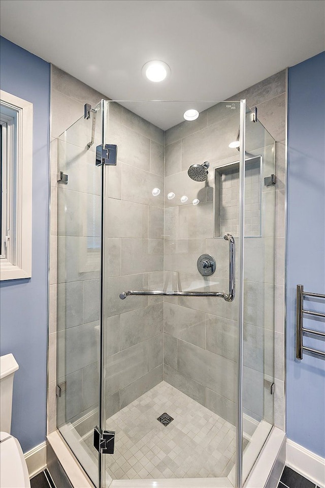 bathroom featuring toilet and an enclosed shower