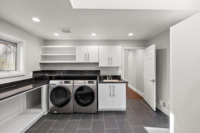 clothes washing area with cabinets, sink, and washing machine and clothes dryer