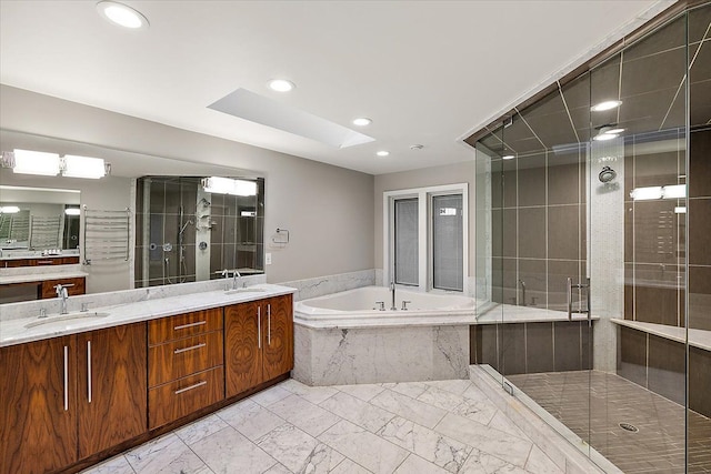 bathroom featuring separate shower and tub, a skylight, and vanity