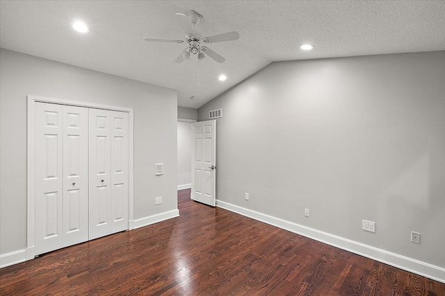 unfurnished bedroom featuring a textured ceiling, ceiling fan, dark hardwood / wood-style flooring, and lofted ceiling