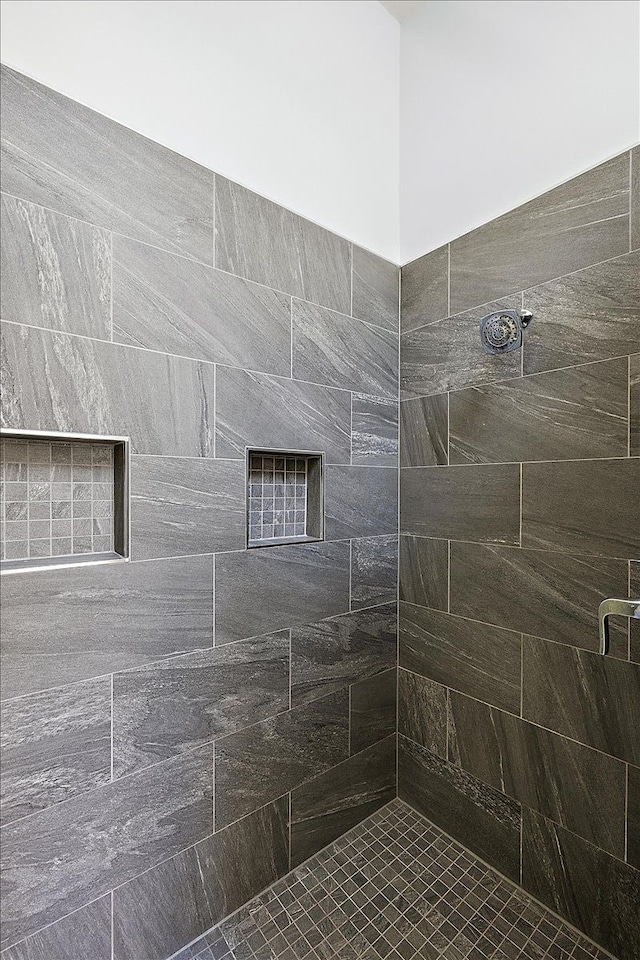 bathroom featuring a tile shower and a fireplace