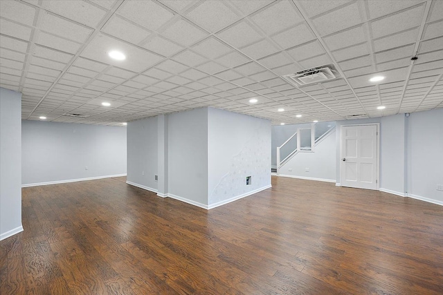 basement featuring dark hardwood / wood-style floors and a drop ceiling