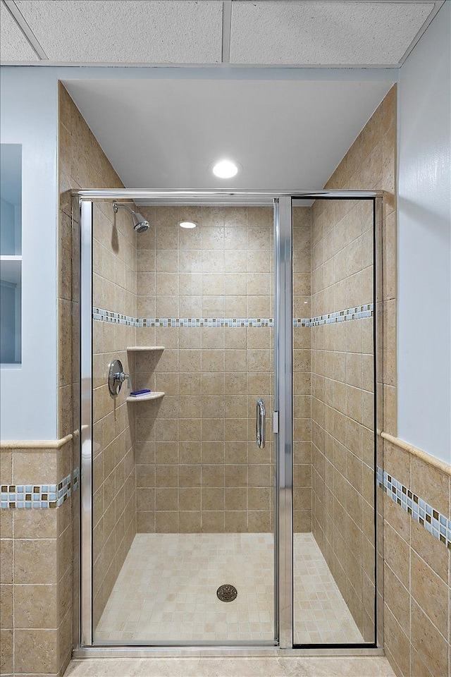 bathroom with tile walls and a shower with shower door