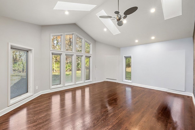 spare room with a skylight, a wealth of natural light, ceiling fan, and hardwood / wood-style flooring